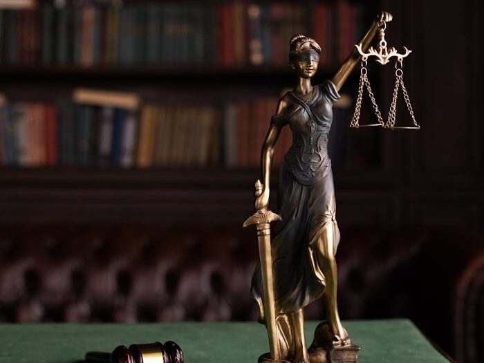 Lady Justice and gavel on a table in a classic law library setting.